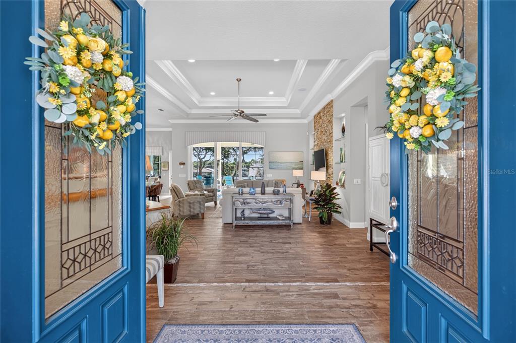 A view through blue double doors into a living room with tile floors and tray ceilings — 28 N WATERVIEW DRIVE, PALM COAST, FL