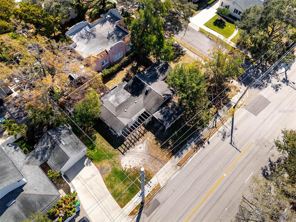 An aerial view shows a house with a dark roof and a wooden pergola structure — 2627 W WATROUS AVENUE, TAMPA, FL
