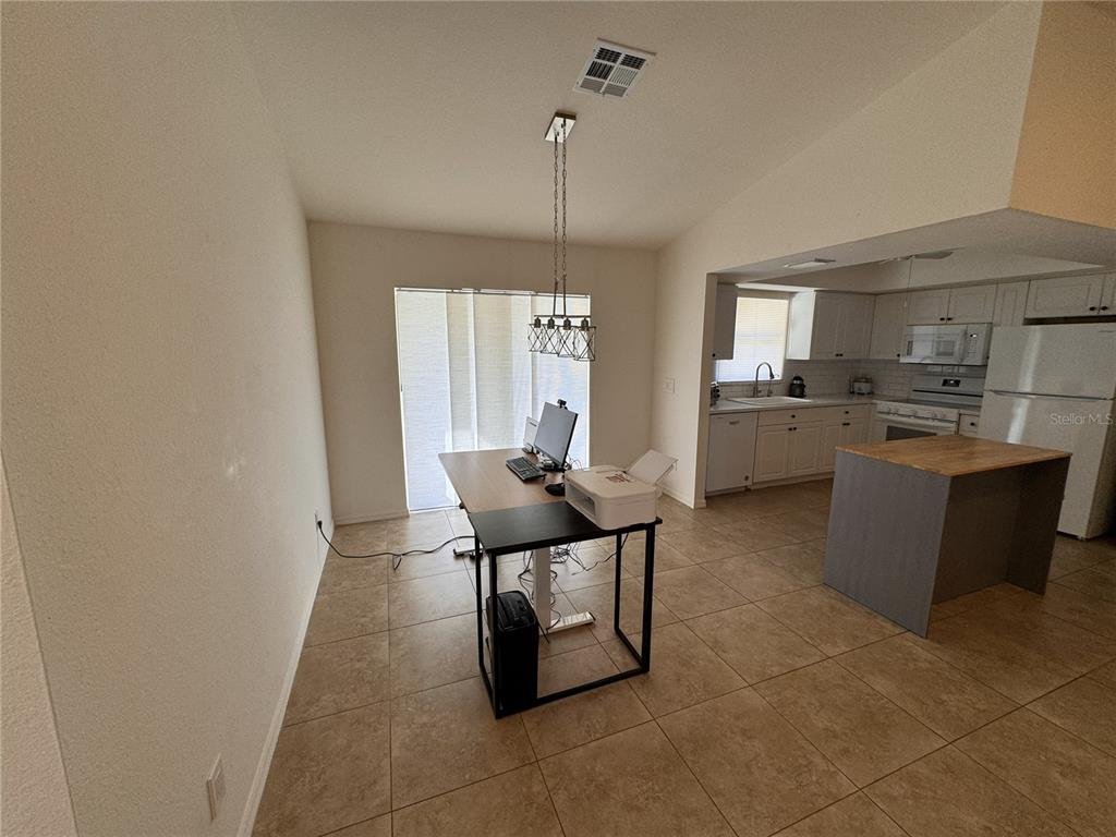 A kitchen with an island and an adjacent dining area currently used as an office — 3806 SW 6TH AVENUE, CAPE CORAL, FL
