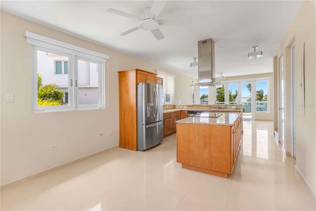 A kitchen with wooden cabinets, stainless steel appliances, a center island, and tile flooring — 7 PASEO DE LA BALANDRAS UNIT 7, DORADO, PR