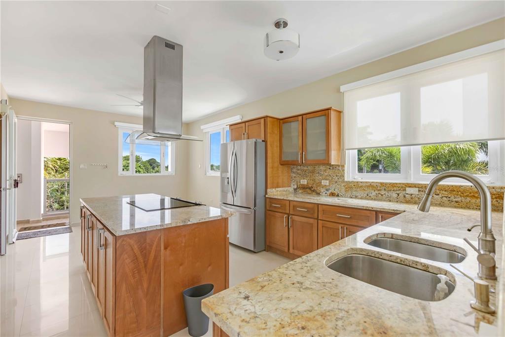 A kitchen with wood cabinets, granite countertops, a stainless steel island hood, and a balcony door — 7 PASEO DE LA BALANDRAS UNIT 7, DORADO, PR