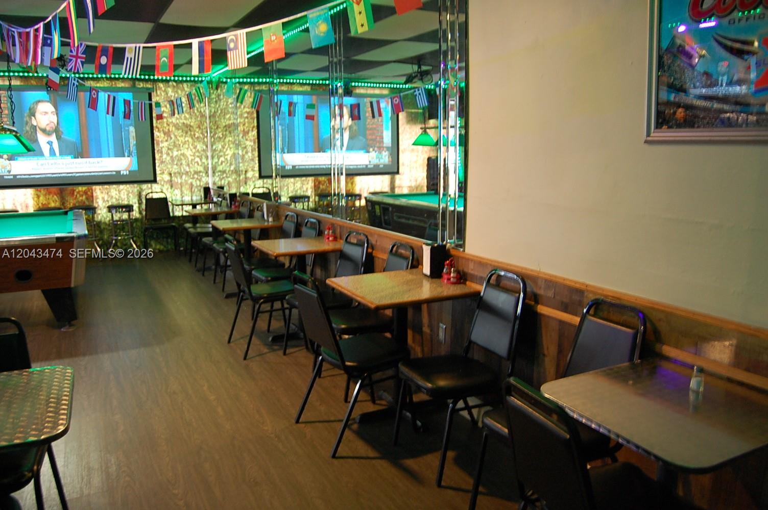A bar interior features rows of tables, black chairs, pool tables, and international flag banners — 883 W 29, Hialeah FL 33012, HIALEAH, FL
