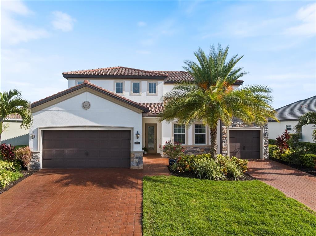 A stone monument sign with the text Arbor Grande stands in a grassy residential entrance — 12120 GANNETT PLACE, LAKEWOOD RANCH, FL