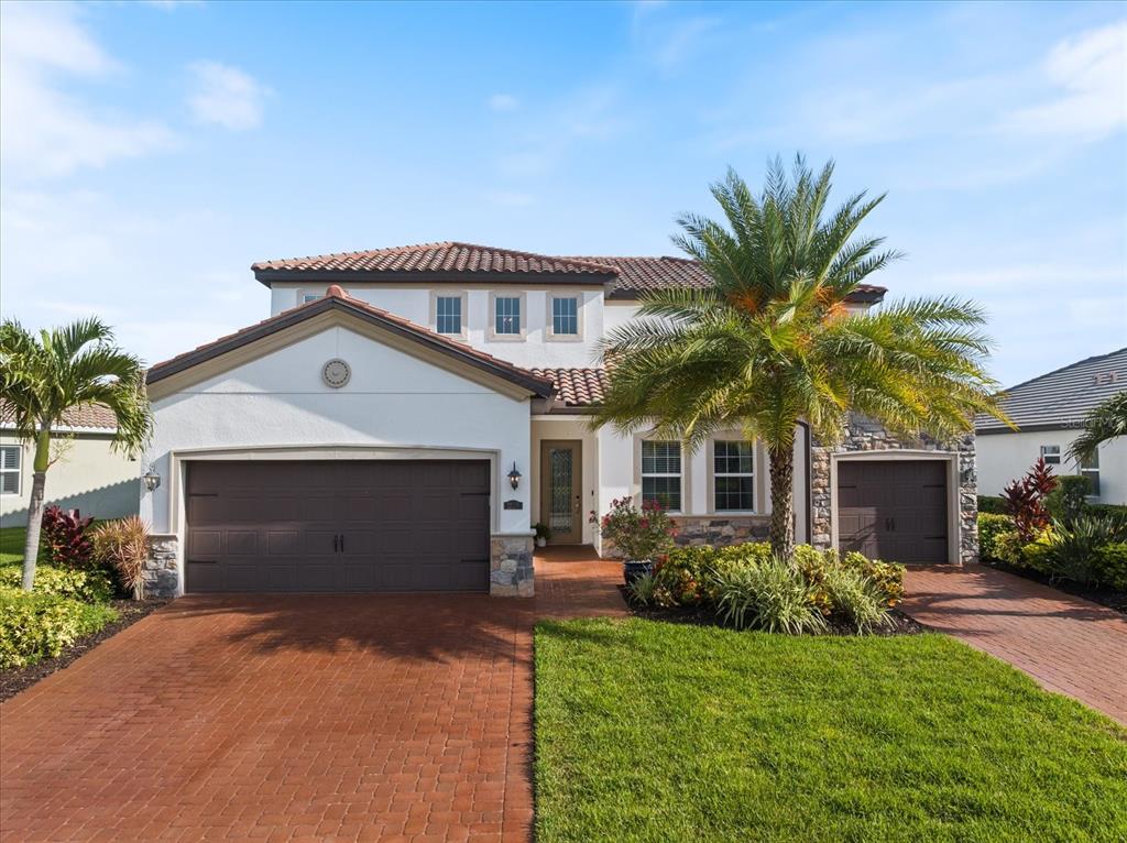 An aerial view shows a two-story house with a screened-in pool patio and tile roof — 12120 GANNETT PLACE, LAKEWOOD RANCH, FL