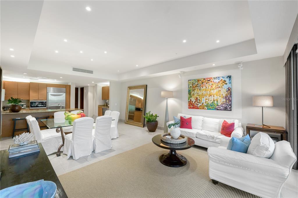 An open-concept living and dining area features white slipcovered furniture, a glass table, and tile flooring — Bahia Beach Golf Club LAS VERANDAS CONDOMINIUM 3119 UNIT 3119, RIO GRANDE, PR