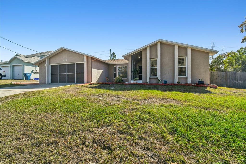 A single-story house with a beige stucco exterior, a two-car garage, and a front lawn — 13170 PIRATE LANE, SPRING HILL, FL