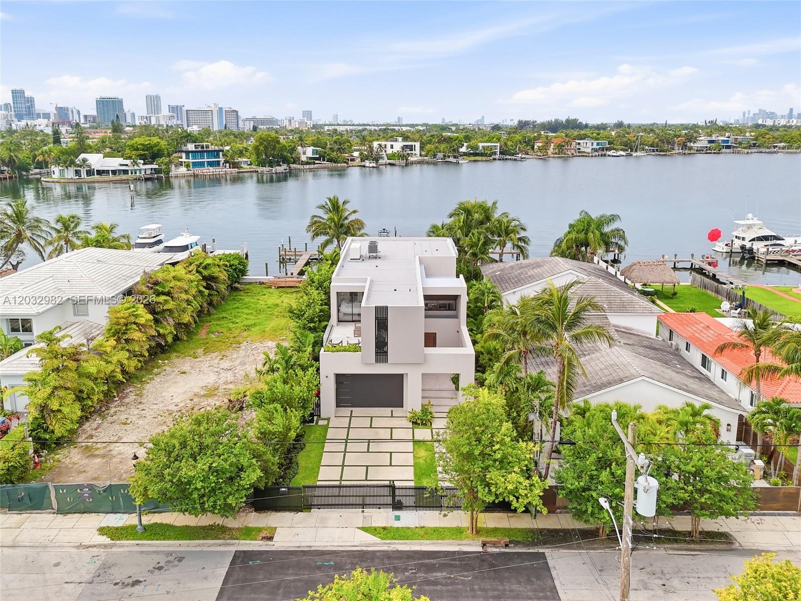 An aerial view shows a modern multi-story house situated on a waterfront lot — 1050 Stillwater Dr, Miami Beach FL 33141, MIAMI BEACH, FL