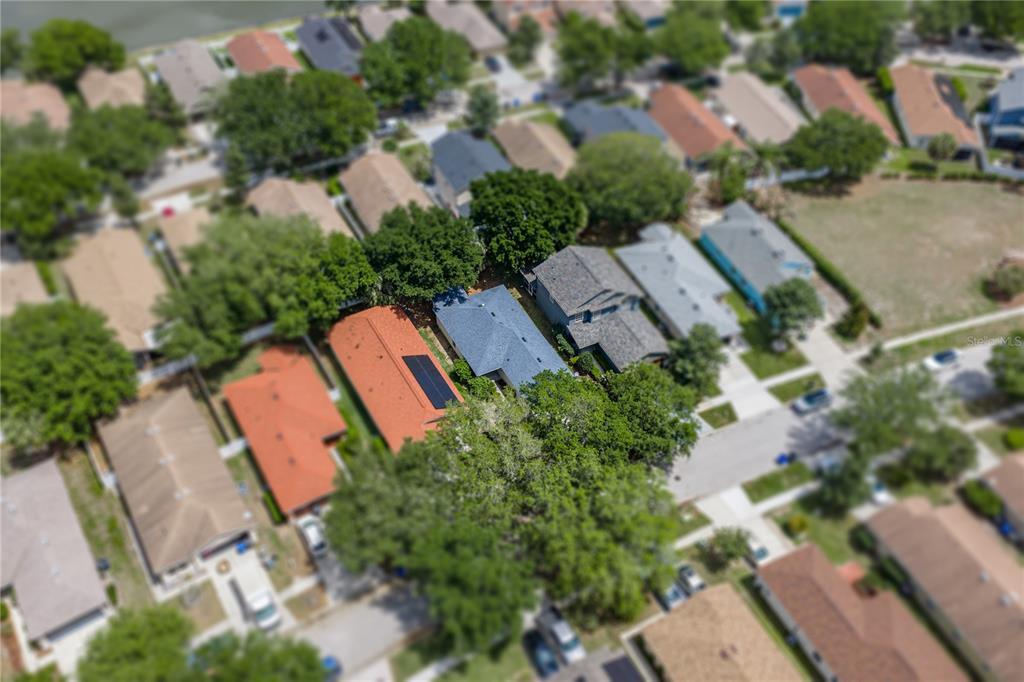 An aerial view shows a suburban neighborhood with houses featuring various roof colors and trees — 11578 HAMMOCKS GLADE DRIVE, RIVERVIEW, FL