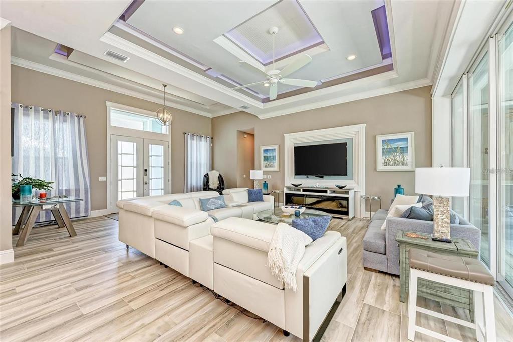 A living room features a white sectional sofa, a tray ceiling, and wood-look tile flooring — 1430 SEA GULL COURT, PUNTA GORDA, FL