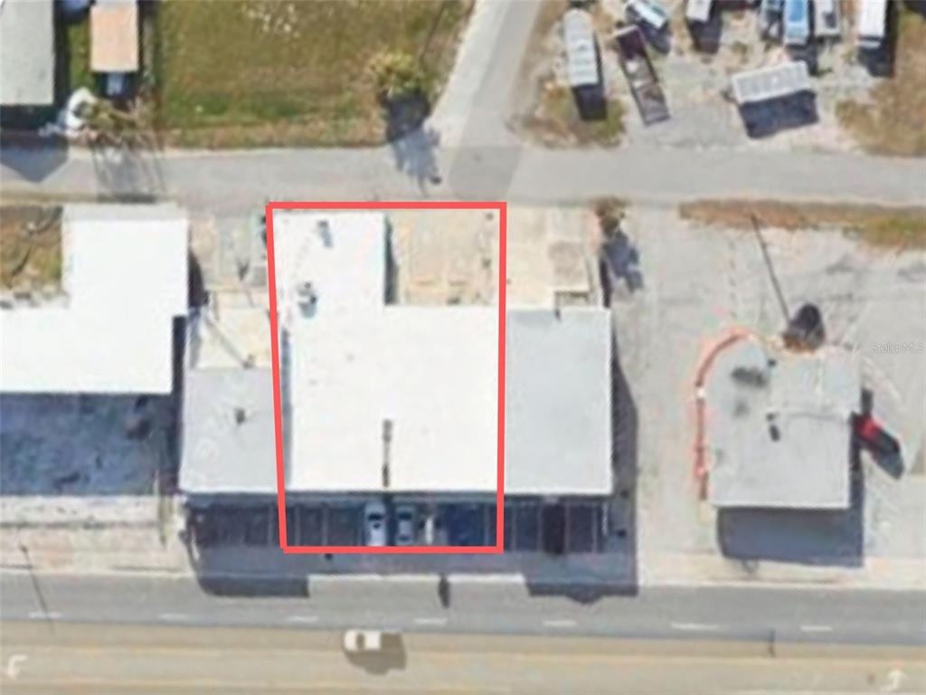 An aerial view shows a rectangular building with a flat roof highlighted by a red border — 2012 S ATLANTIC AVENUE, DAYTONA BEACH, FL