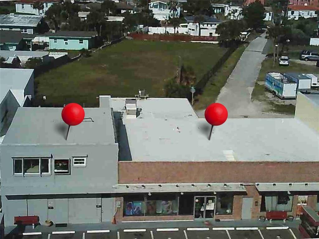 An aerial view shows the flat roof of a commercial building with two red pins — 2012 S ATLANTIC AVENUE, DAYTONA BEACH, FL