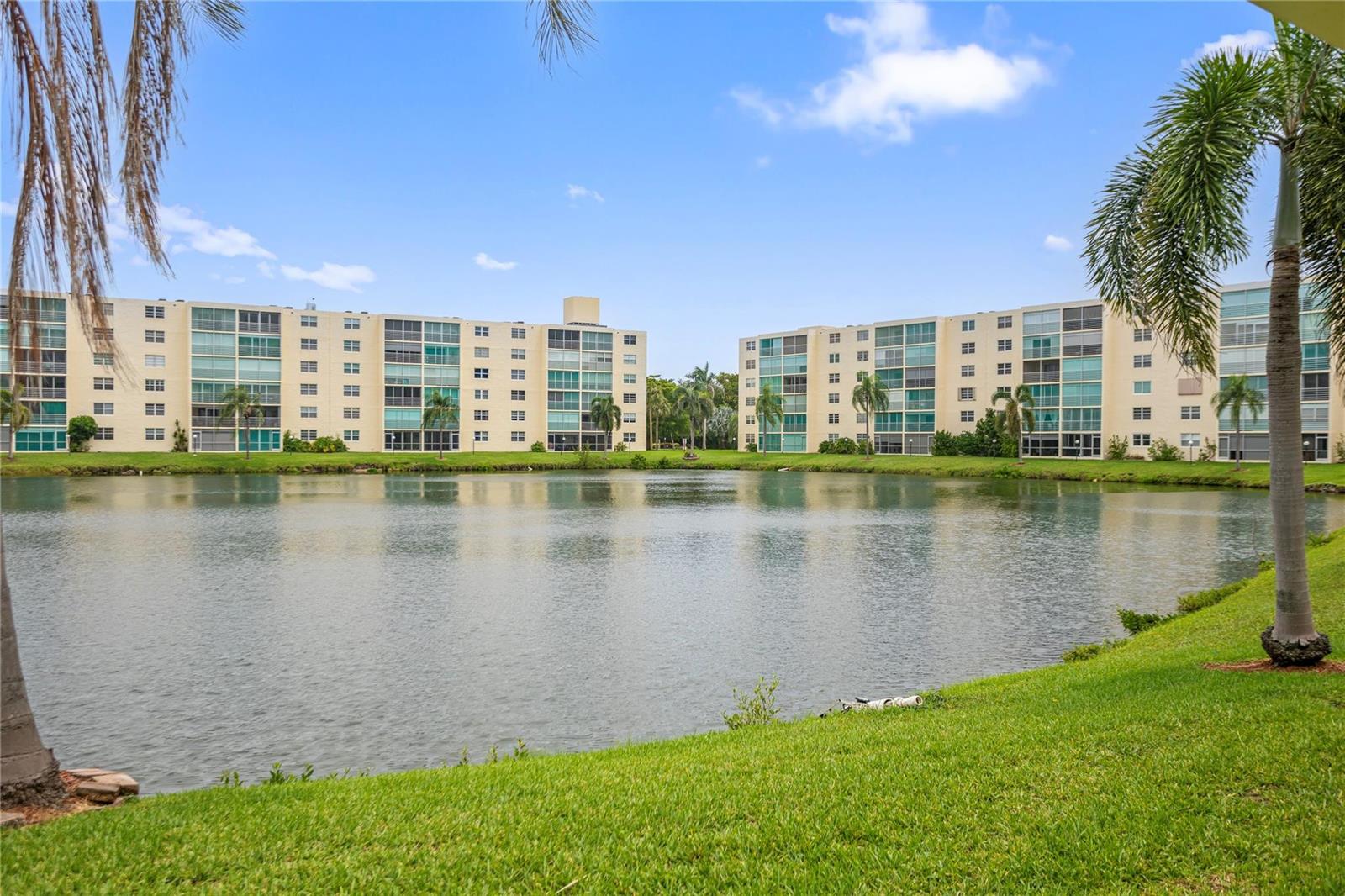 A view of a lake surrounded by multi-story apartment buildings and palm trees — 101 SE 3rd Avenue # 605, Dania Beach FL 33004, DANIA BEACH, FL