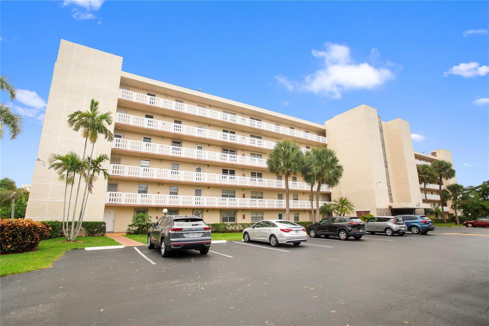 A multi-story apartment building with balconies and a parking lot in front — 101 SE 3rd Avenue # 605, Dania Beach FL 33004, DANIA BEACH, FL