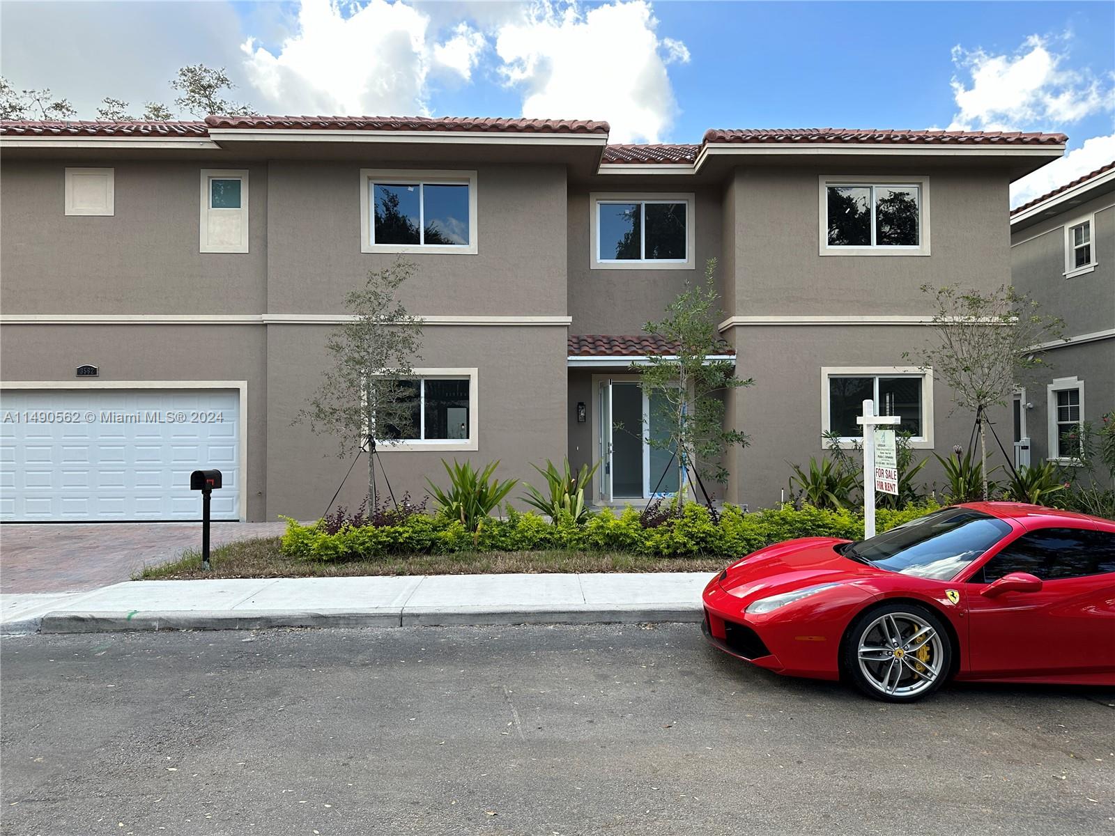 A two-story tan townhouse with a red tile roof and a red sports car parked outside — 3562 Forest View Cir, Dania Beach FL 33312, DANIA BEACH, FL