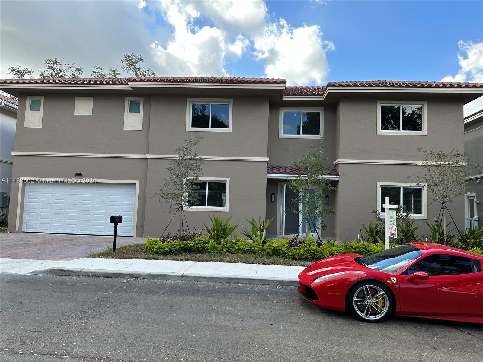 A two-story house with a beige stucco exterior and a red Ferrari parked in front — 3562 Forest View Cir, Dania Beach FL 33312, DANIA BEACH, FL