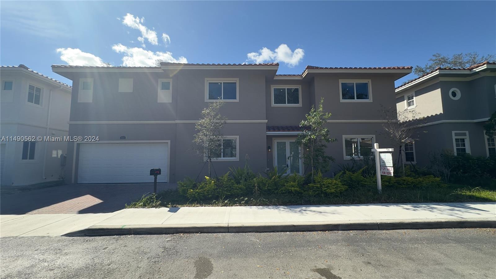 A two-story suburban house with a white garage door and a for sale sign — 3562 Forest View Cir, Dania Beach FL 33312, DANIA BEACH, FL