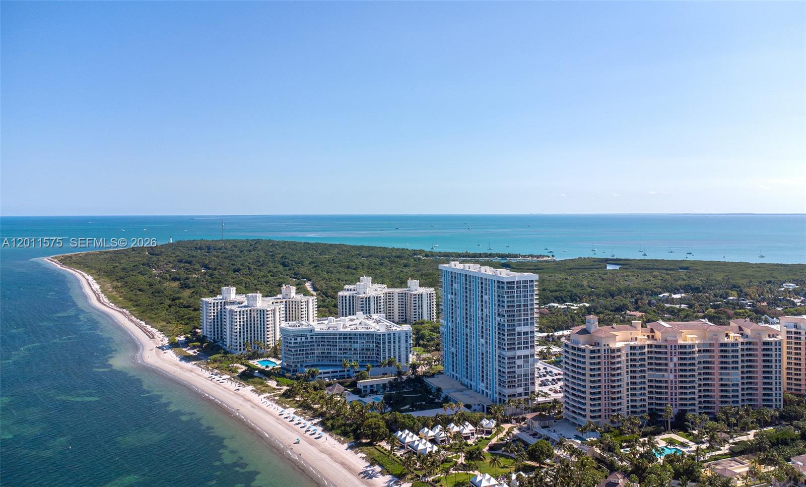 An aerial view shows several high-rise residential buildings situated along a sandy beach — 881 Ocean Dr # 7D, Key Biscayne FL 33149, KEY BISCAYNE, FL