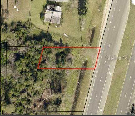 An aerial view shows a rectangular plot of land outlined in red next to a highway — US-231, FOUNTAIN, FL
