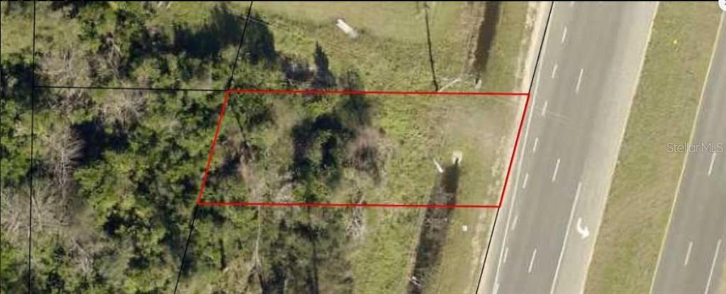 An aerial view shows a rectangular plot of land outlined in red next to a road — US-231, FOUNTAIN, FL