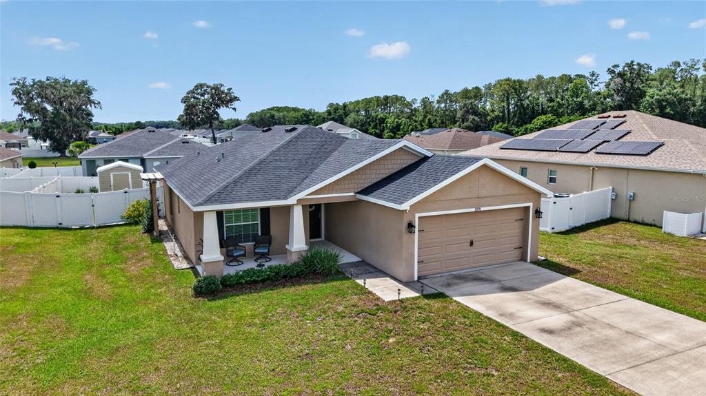 An exterior view of a single-story suburban house with a two-car garage and driveway — 8970 SE 49TH COURT ROAD, OCALA, FL