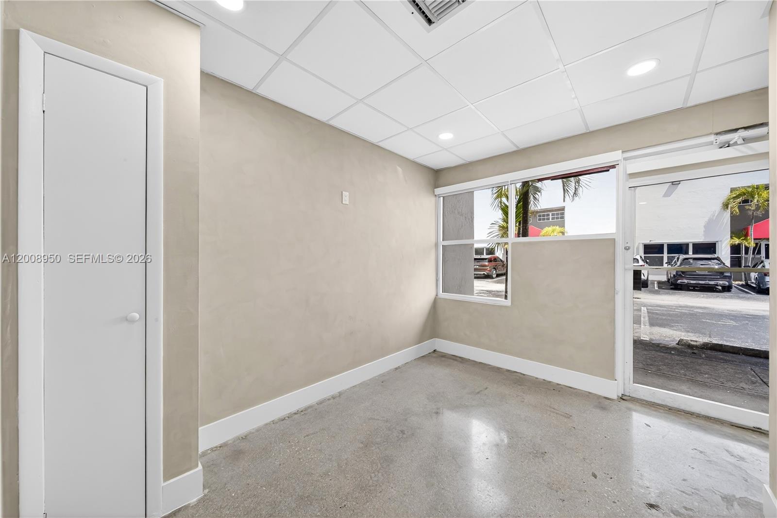 An empty office space features beige walls, a drop ceiling, and a concrete floor — 12305 SW 133rd Ct # 26, Miami FL 33186, MIAMI, FL