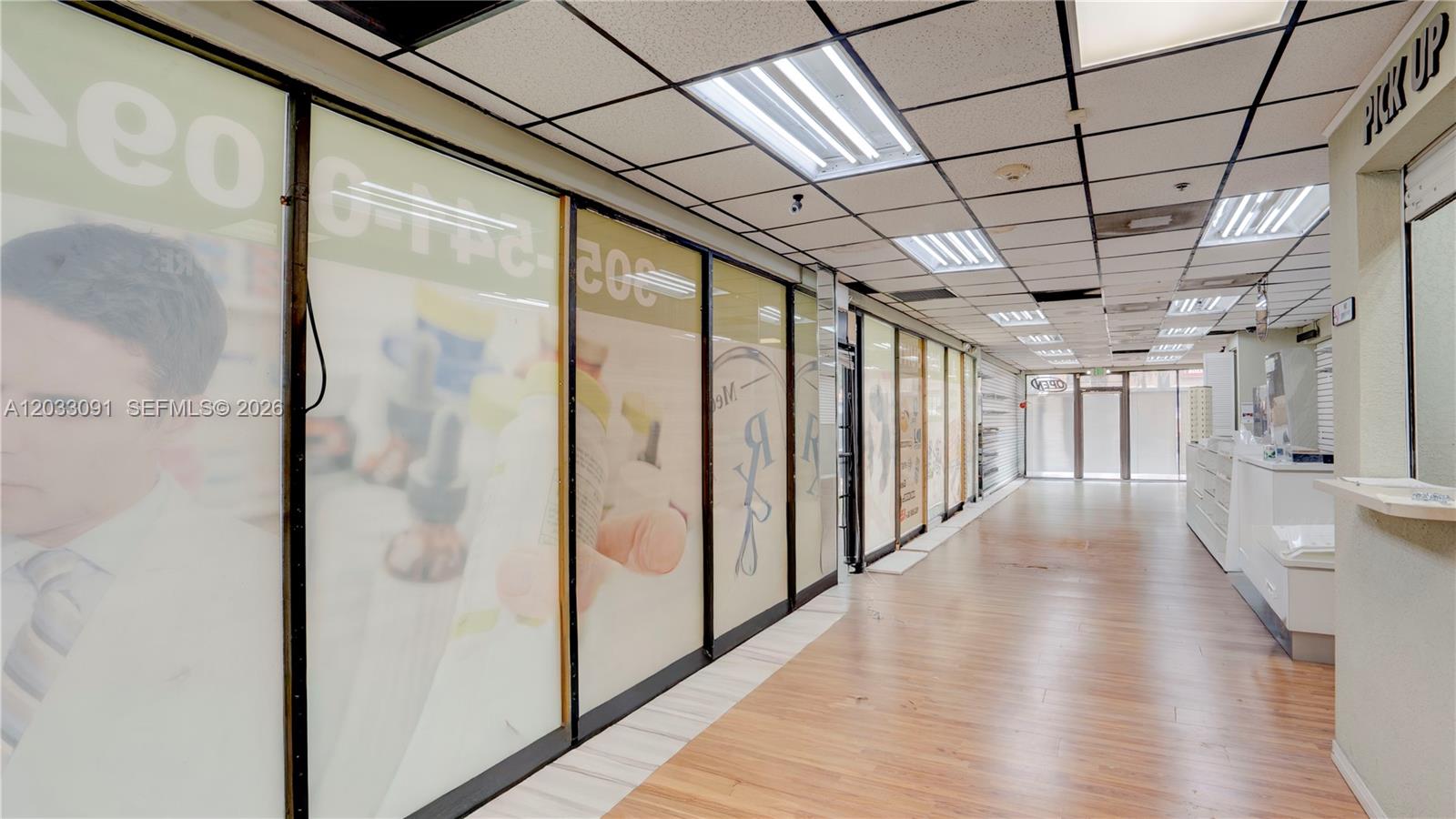 A commercial space features wood-look flooring, a drop ceiling with fluorescent lights, and glass partitions — 304 SW 12 Ave, Miami FL 33130, MIAMI, FL