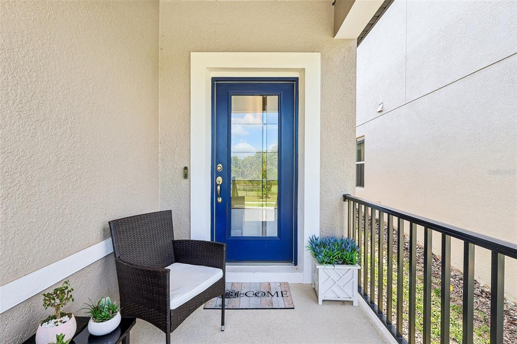 A blue front door with a glass insert opens onto a small covered porch — 12103 EASTMOOR DRIVE, WINTER GARDEN, FL