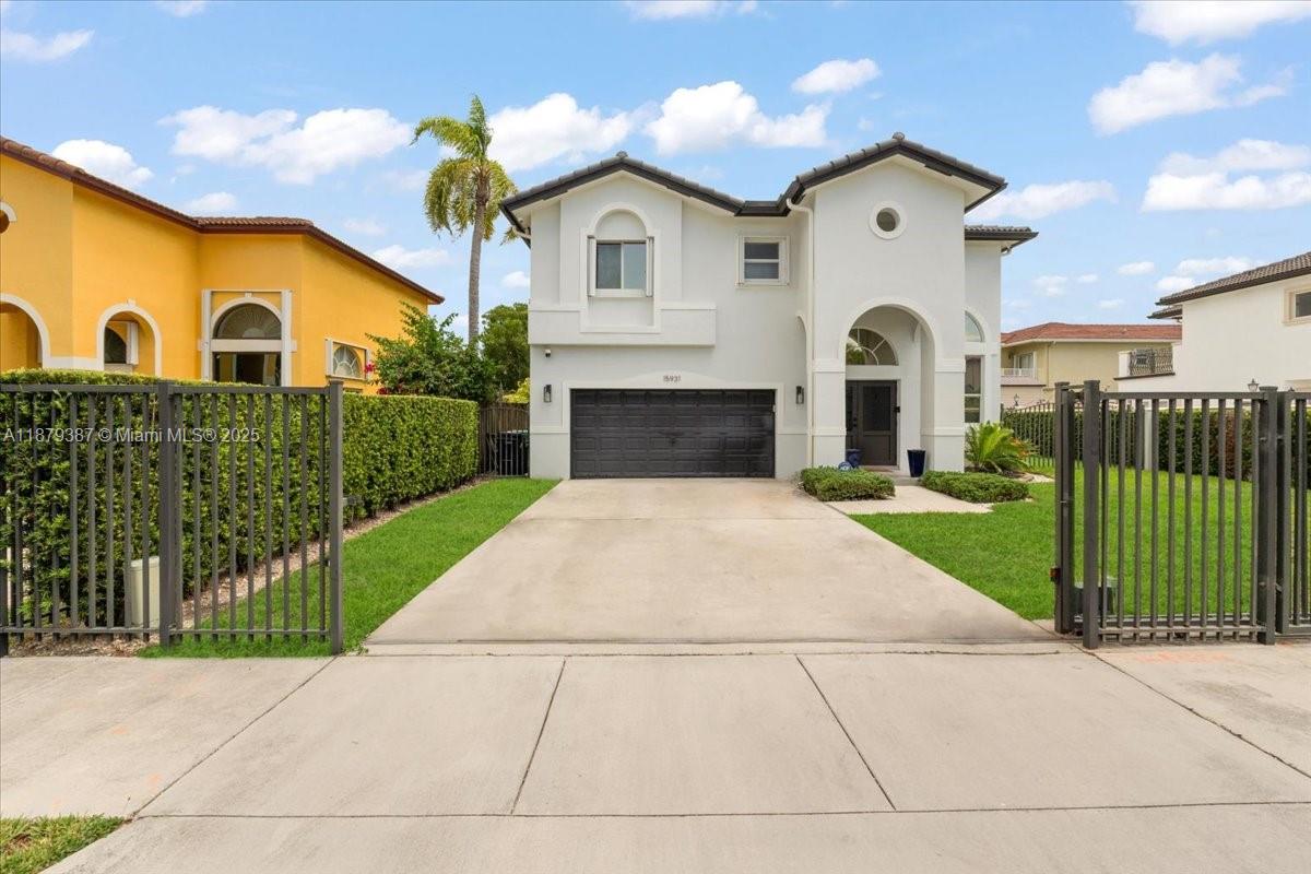 A two-story house with a white exterior, a dark garage door, and a gated driveway — 15931 SW 61st Ln, Miami FL 33193, MIAMI, FL