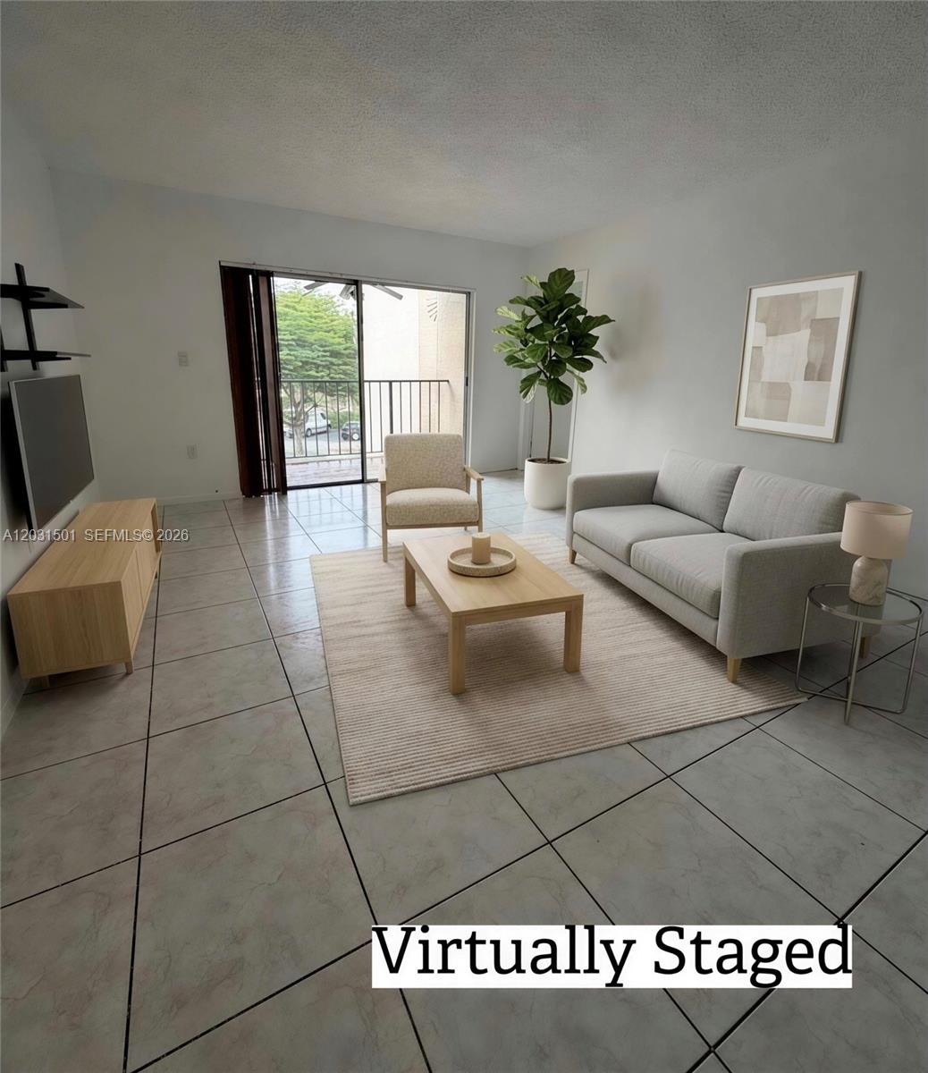This living room features light tile flooring, a sliding glass door, and virtual furniture staging — 13701 Kendale Lakes Cir # 308, Miami FL 33183, MIAMI, FL