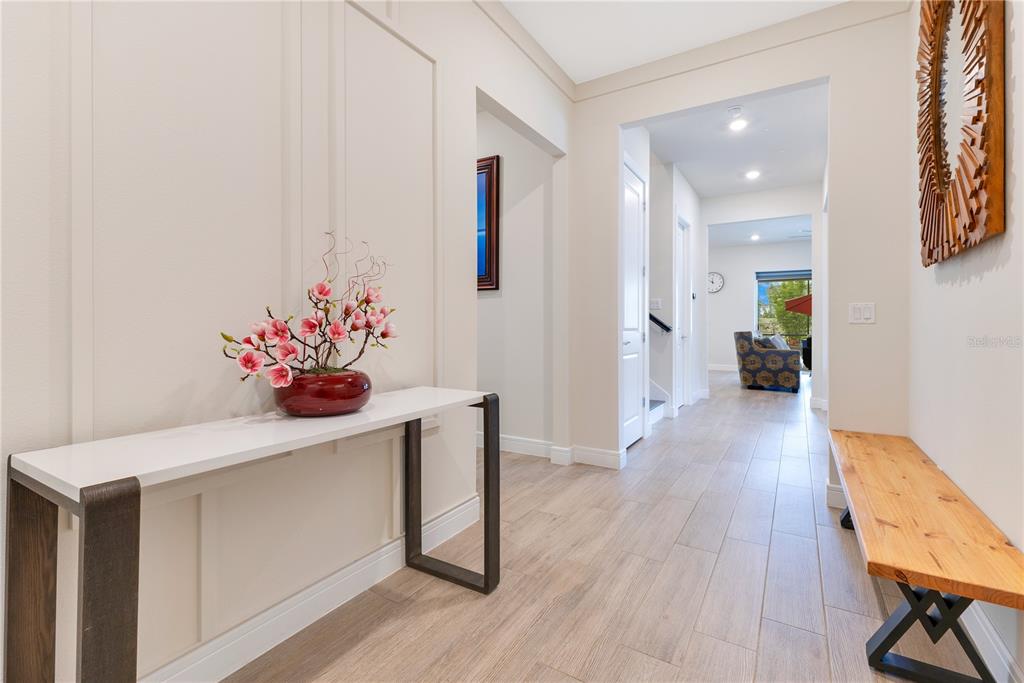 A bright entryway features a white console table, a wooden bench, and light wood flooring — 13330 PANAMA BEACH COURT, ORLANDO, FL