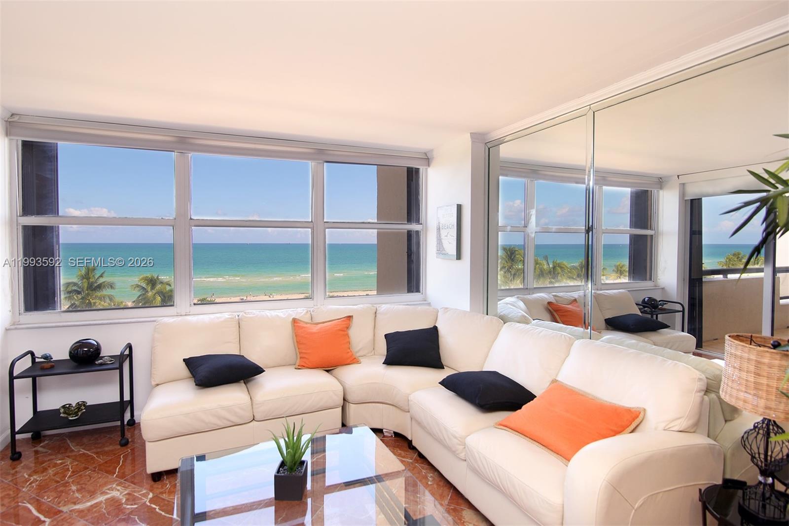 A living room with a white sectional sofa, glass coffee table, and ocean views — 2555 Collins Ave # 703, Miami Beach FL 33140, MIAMI BEACH, FL