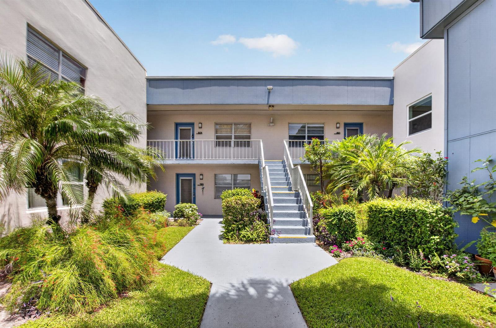 A two-story apartment building exterior features a central staircase, walkways, and landscaped front gardens — 809 Normandy Q # 809, Delray Beach FL 33484, DELRAY BEACH, FL