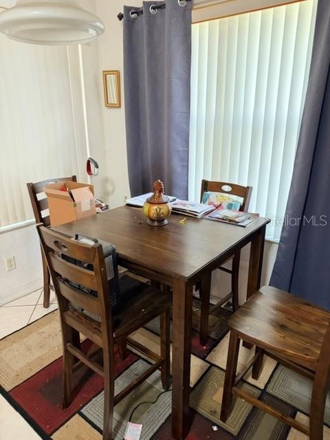 A dining area features a wooden table and chairs set on a patterned rug — 719 CORVINA DRIVE, DAVENPORT, FL