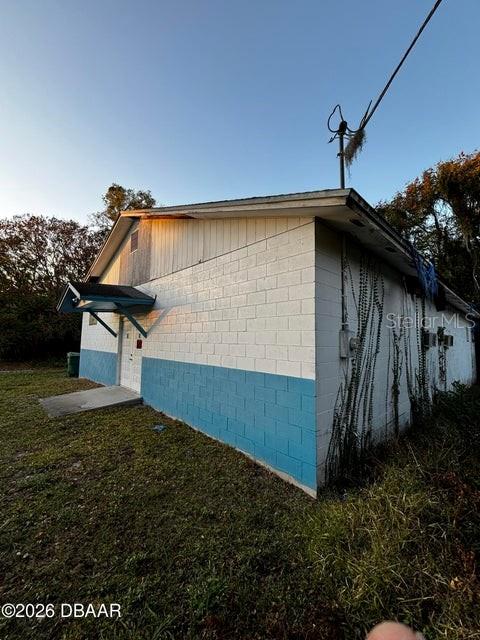 A single-story building with white concrete block walls and a blue painted base — 227 W VOORHIS AVENUE, DELAND, FL