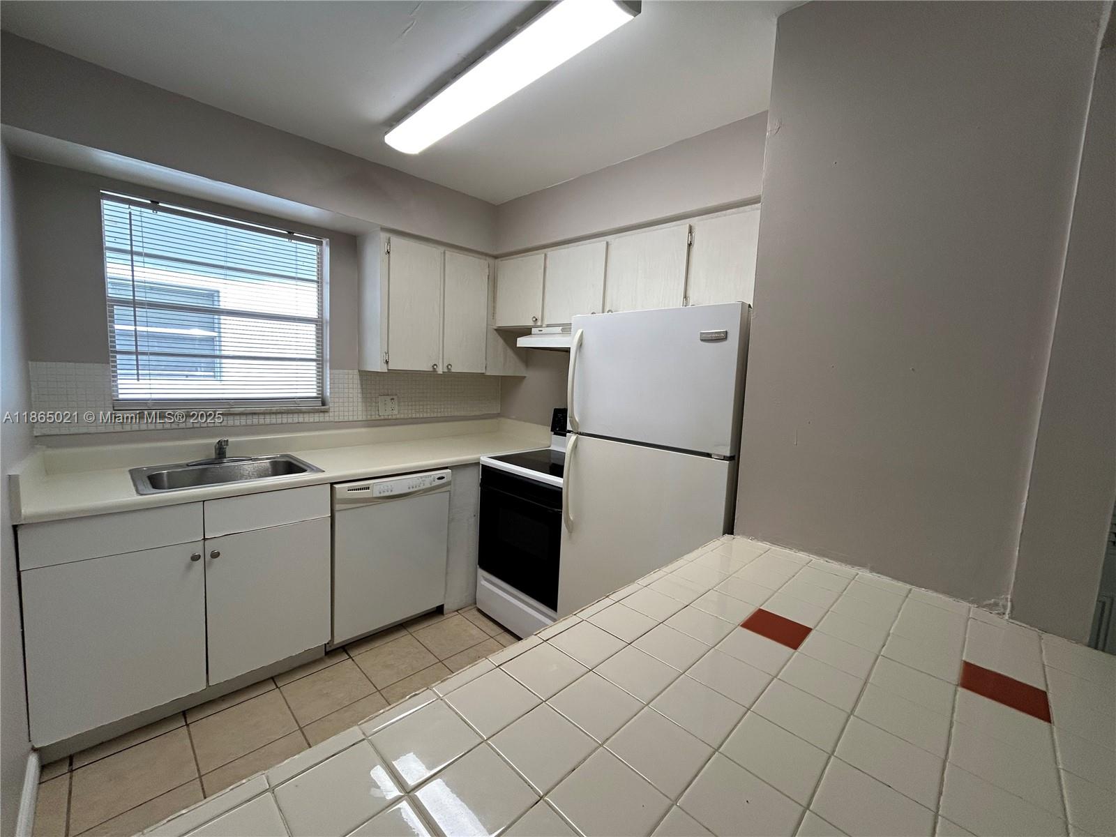 A kitchen features white cabinets, white appliances, a tiled countertop, and a tiled floor — 6505 Winfield Blvd # 18, Margate FL 33063, MARGATE, FL