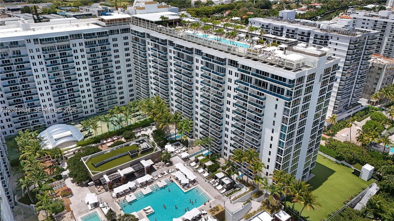 An aerial view shows a large white apartment complex with a rooftop pool and courtyard — 2301 Collins Ave # 414, Miami Beach FL 33139, MIAMI BEACH, FL
