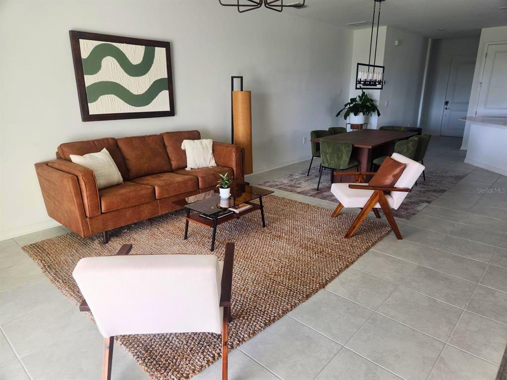 A living and dining room features a brown sofa, two armchairs, and a wooden table — 4615 WANDSWORTH WAY, DAVENPORT, FL