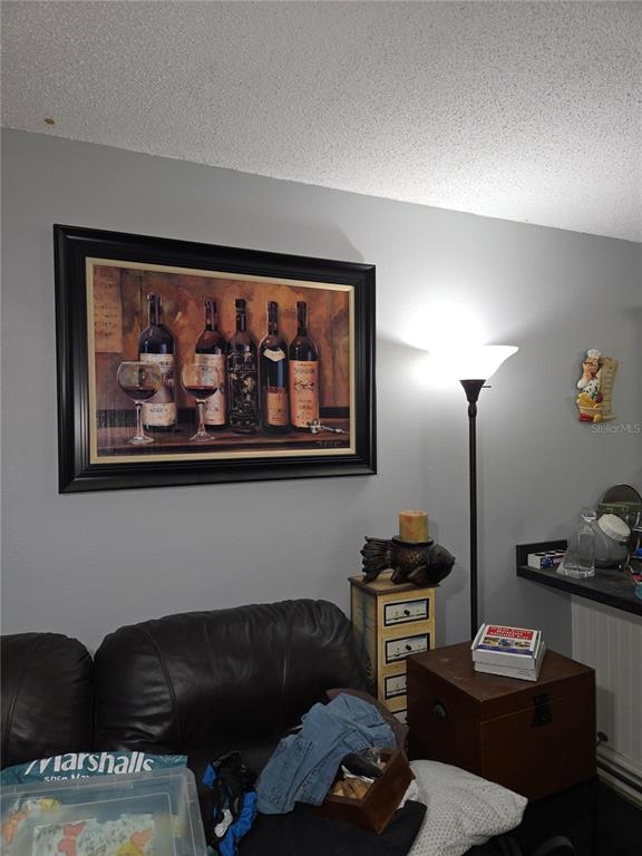 A living room area features a large wine-themed framed print hanging above a black sofa — 6400 46TH AVENUE N UNIT 305, KENNETH CITY, FL
