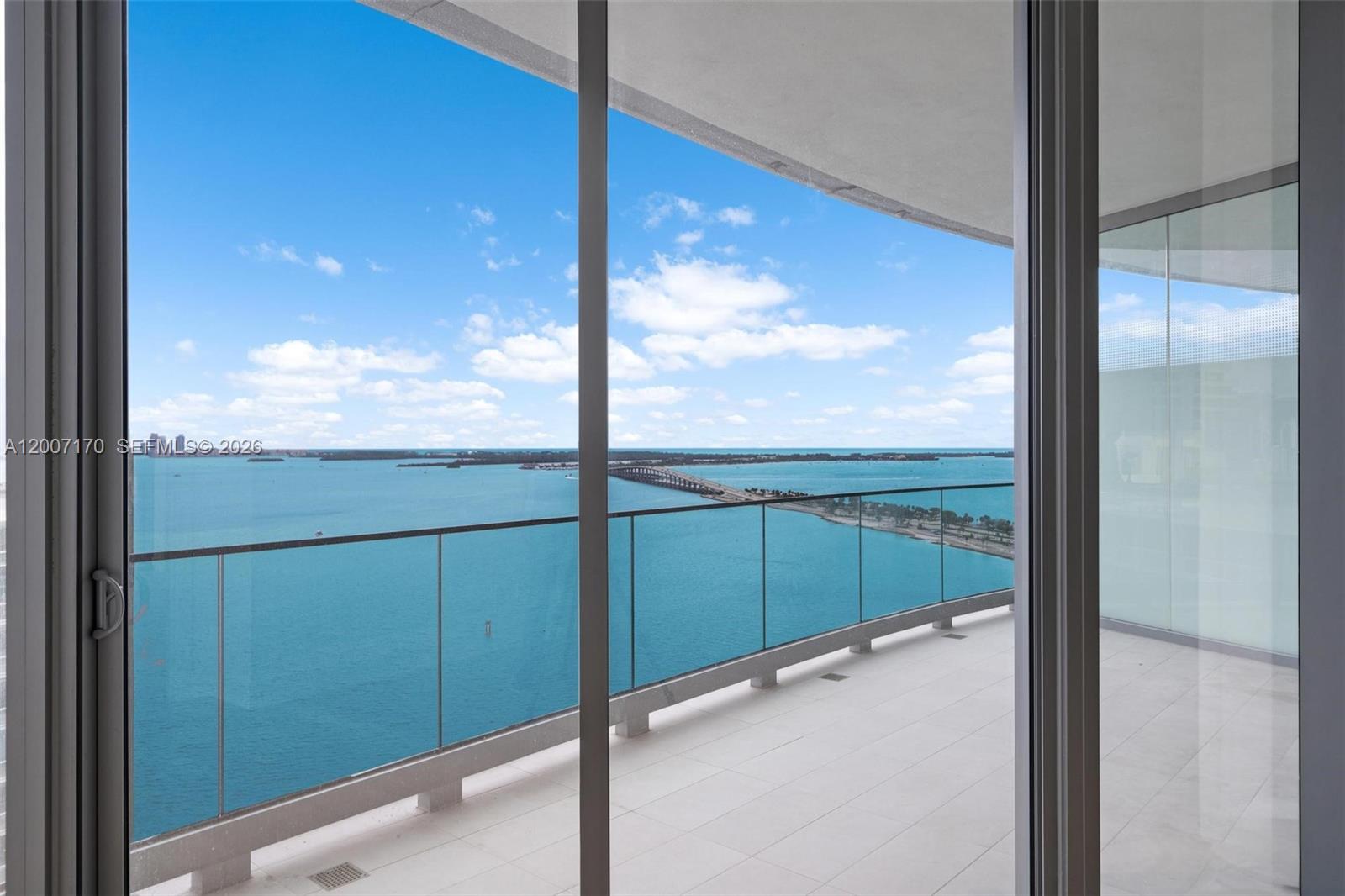 A balcony with a glass railing overlooks a bridge spanning a large body of water — 175 SE 25th RD # 1904, Miami FL 33129, MIAMI, FL