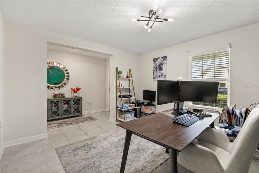 A home office features a desk with dual monitors, a bookshelf, and a tiled floor — 545 S ANDREA CIRCLE, HAINES CITY, FL