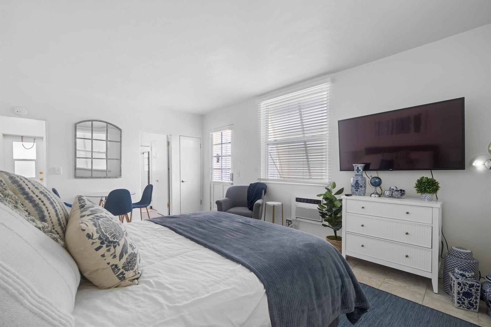A bedroom features a bed with blue bedding, a white dresser, and a wall-mounted television — 172 N County Road # 5, Palm Beach FL 33480, PALM BEACH, FL