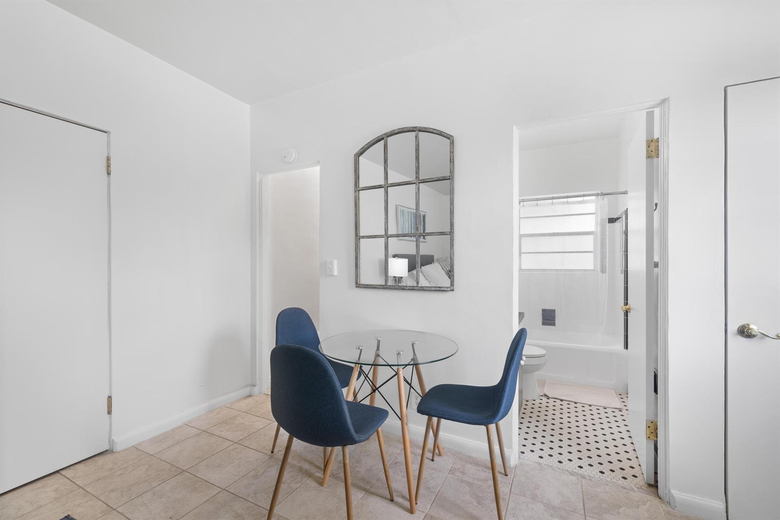 A small dining area features a glass table, three blue chairs, and a wall mirror — 172 N County Road # 5, Palm Beach FL 33480, PALM BEACH, FL