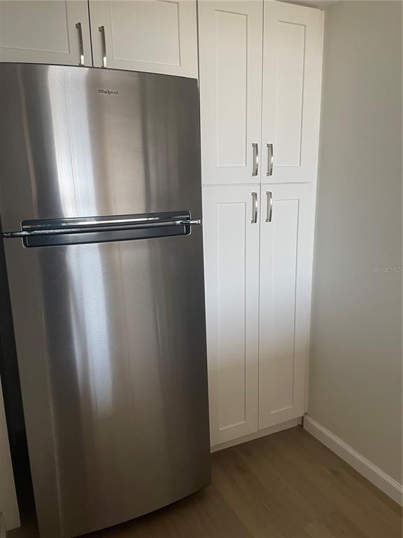 A stainless steel Whirlpool refrigerator stands next to white shaker-style pantry cabinets in a kitchen — 6269 PALMA DEL MAR BOULEVARD S UNIT 501, ST PETERSBURG, FL