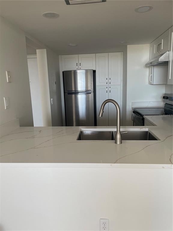 A kitchen features white cabinets, stainless steel appliances, and a white quartz countertop island — 6269 PALMA DEL MAR BOULEVARD S UNIT 501, ST PETERSBURG, FL