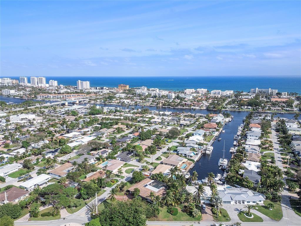 An aerial view shows a residential neighborhood with canals leading toward the ocean — 556 SE 15th Avenue, Deerfield Beach FL 33441, DEERFIELD BEACH, FL