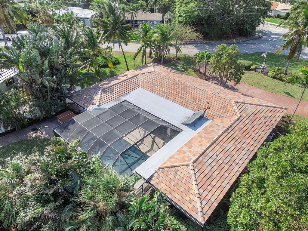 An aerial view of a house with a tiled roof and a screened-in pool enclosure — 556 SE 15th Avenue, Deerfield Beach FL 33441, DEERFIELD BEACH, FL
