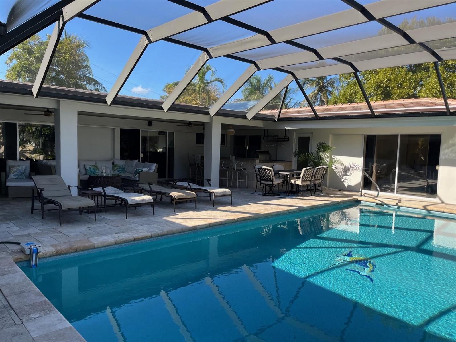 A swimming pool with a screen enclosure and a covered patio with outdoor furniture — 556 SE 15th Avenue, Deerfield Beach FL 33441, DEERFIELD BEACH, FL