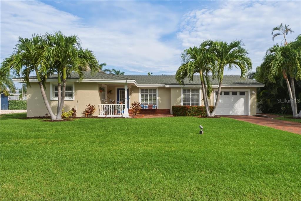 A single-story house with a green lawn, palm trees, and a white garage door — 508 83RD STREET, HOLMES BEACH, FL