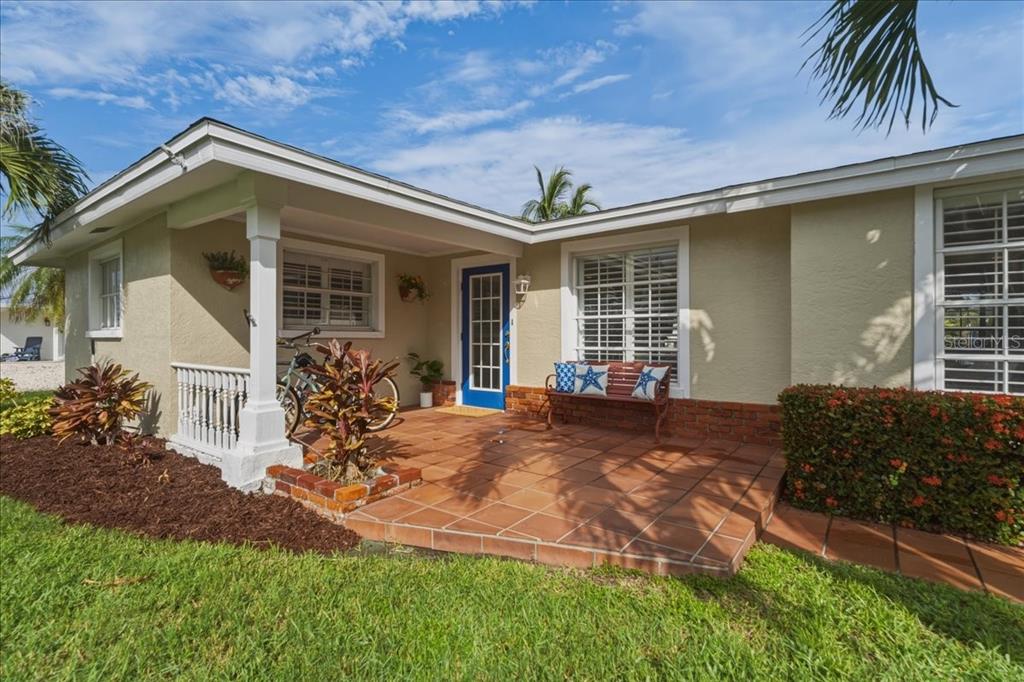 A one-story house exterior features a tiled front porch, a blue door, and a bicycle — 508 83RD STREET, HOLMES BEACH, FL