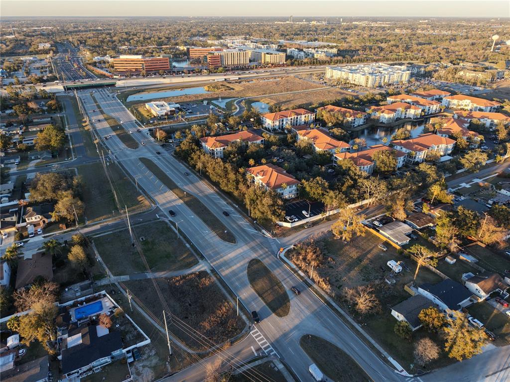 An aerial view shows a multi-lane road intersecting near residential apartment complexes and suburban homes — 2628 HERBISON DRIVE, ORLANDO, FL